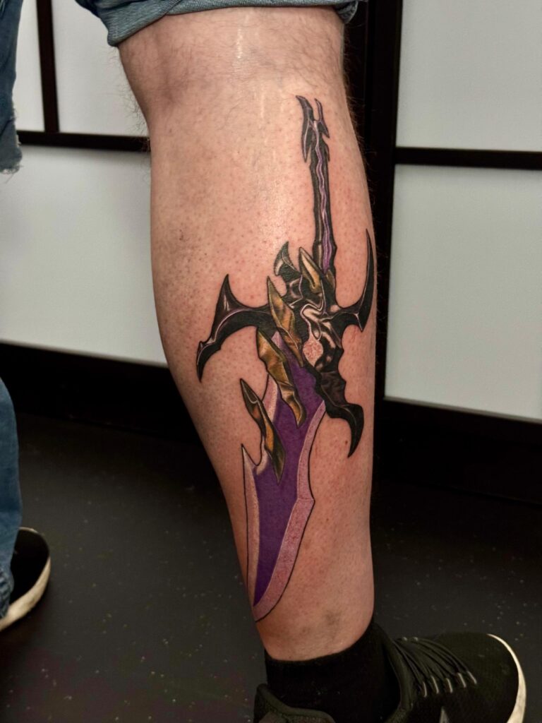 Anime Tattoo am Unterschenkel mit Schwertmotiv in Farbe, gestochen im Tattoo Studio in Straubing